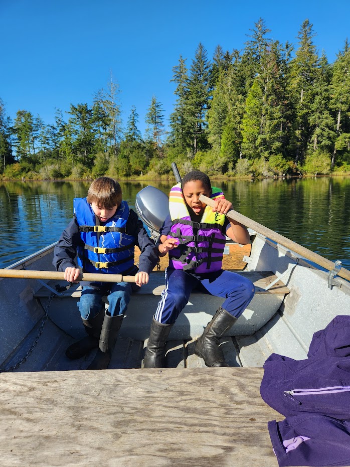 students on field trip in a row boat